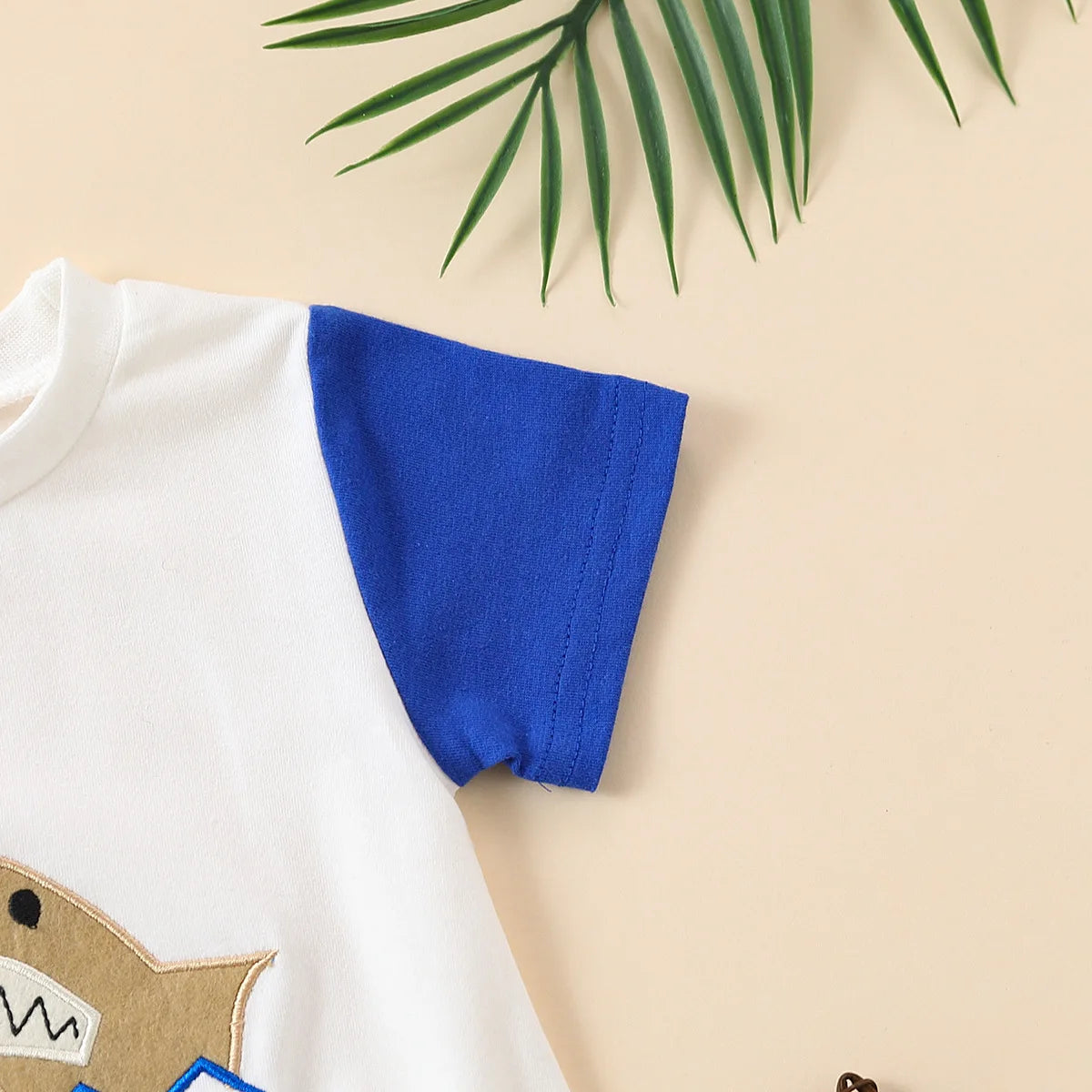 Romper triangular de manga corta con bordado de tiburón y toalla, color neutro para bebé, ideal para el verano.